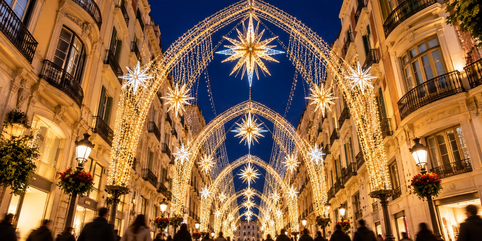 Christmas light arches and stars over a pedestrian street of 19th-century buildings in central Malaga at night